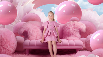 Pink ruffle girls party dress with balloons and fluffy backdrop
