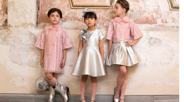 Girls wearing Mama Luma luxury occasion outfits — silver metallic dress with rose appliqué and pastel pink sequin tops with bows, perfect for weddings, Eid and milestone celebrations