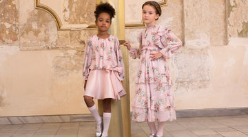 Girls wearing Mama Luma pastel pink floral dresses — long-sleeve dress with scalloped lace hem and floral blouse with satin bow skirt, luxury occasionwear for birthdays, Eid and weddings