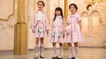 Girls wearing Mama Luma pastel pink luxury outfits — floral embroidered skirt set, long-sleeve floral waist dress with rosette detail, and pleated satin dress with matching bag, perfect for Eid, weddings and birthdays