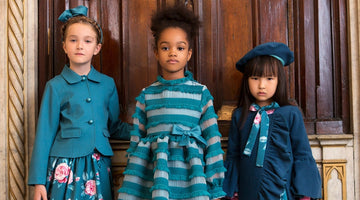 Girls wearing Mama Luma teal and navy couture outfits — floral skirt set with tailored jacket, striped fringe dress with bow waist, and navy beret outfit with floral scarf, luxury occasionwear perfect for Eid, weddings and milestone celebrations