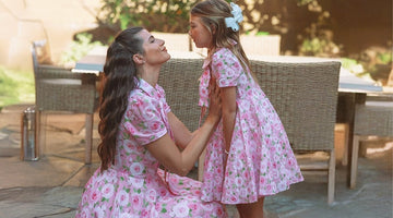 A mother and daughter share a sweet moment wearing matching pink floral dresses from Mama Luma’s collection—perfect for family gatherings, weddings, and spring celebrations.