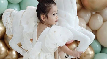 ecru dress with balloon sleeves and a big bow for little girls