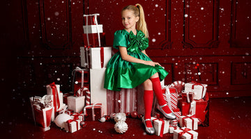 christmas setting green luxury shimmering dress red socks and silver mary jane shoes gift boxes and red background