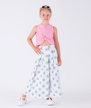 sleeveless pink top paired with a flowing white pants adorned with soft blue floral patterns