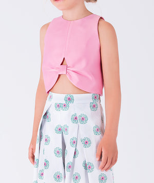 sleeveless pink top and flowing white pants adorned with soft blue floral patterns