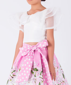 white ruffled blouse and pink floral skirt with a polka dotted bow