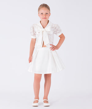 Classic white skirt paired with a puff-sleeve top adorned with a bow
