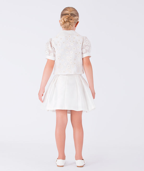 Classic white skirt and puff-sleeve top adorned with a bow and daisy prints