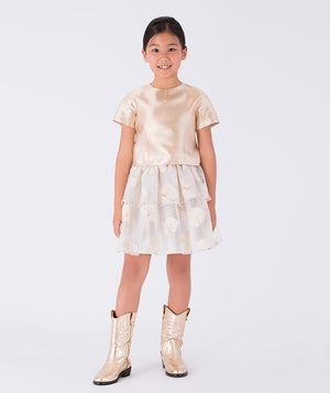 A satin gold blouse paired with a layered ivory skirt