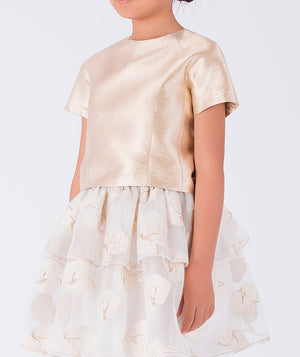 satin gold blouse paired with a layered ivory skirt