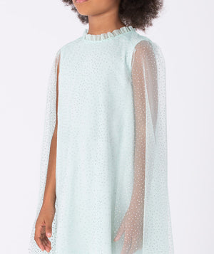A magical mint green dress with glittery mesh cape sleeves, ruffled neckline, and matching oversized bow