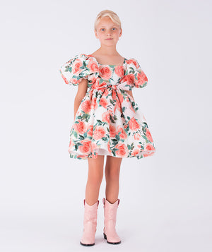 A delightful puff-sleeve dress with a vibrant rose print and bow-tied waist