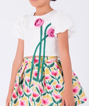  floral print skirt and a white top with 3D pink flowers