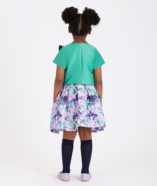 a colorful floral skirt with a blouse with a bold navy bow