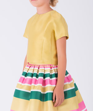 yellow top paired with a joyful striped skirt