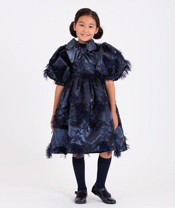 a navy blue puff-sleeve dress with a large bow and floral detailing