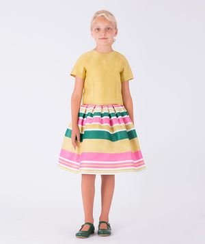 A sunny yellow top paired with a joyful striped skirt