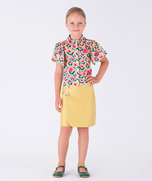 A lively floral shirt paired with a sleek yellow skirt