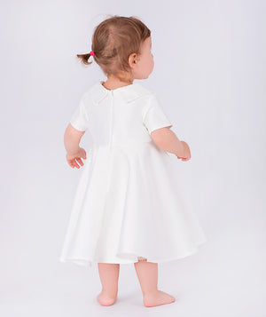 Adorable baby dress in white with short sleeves, a fitted bodice, and a full skirt