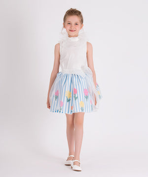 white organza blouse with blue and white striped skirt that has colorful flower prints