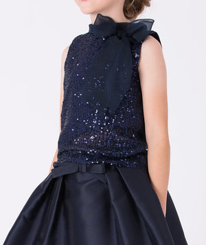 A sleeveless navy glitter blouse with an airy organza bow—effortlessly polished.