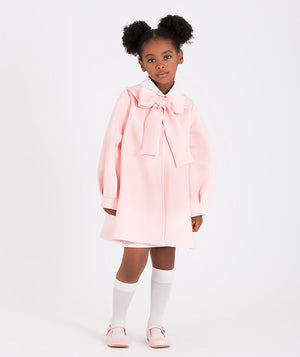 a pink coat with a large bow detail