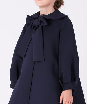 Navy jacket with puff sleeves and a statement bow on the front
