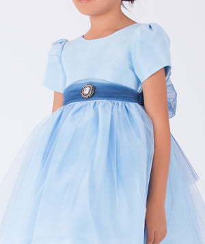 baby blue dress with an organza navy belt that has a diamond brooch