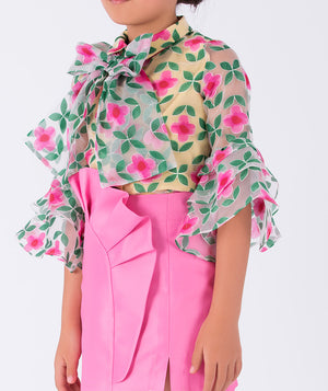 vibrant floral blouse with dramatic bell sleeves, paired with a pink ruffled skirt