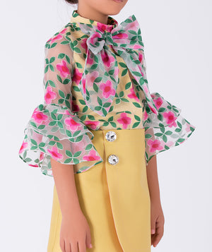 bold floral blouse with bell sleeves, styled with a minimal yellow skirt