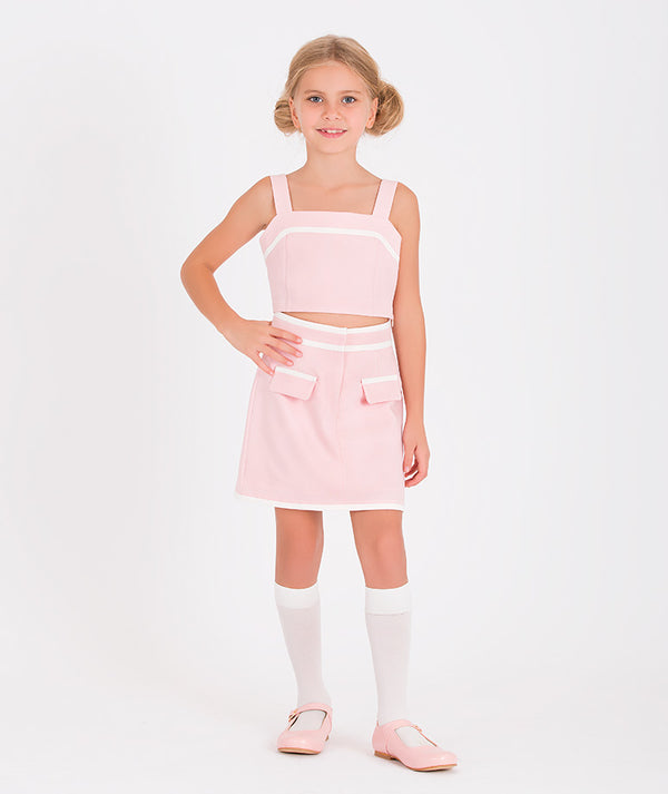 a pink crop top and matching skirt with white accents, featuring large pockets