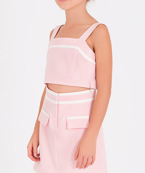 pink two-piece outfit with a sleeveless crop top and a skirt with front pockets and white detailing