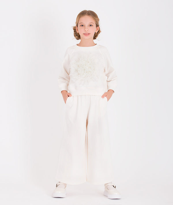 a white tracksuit with a large 3D flower applique