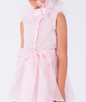 chic pink blouse with ruffled neckline and shimmering skirt with a bow