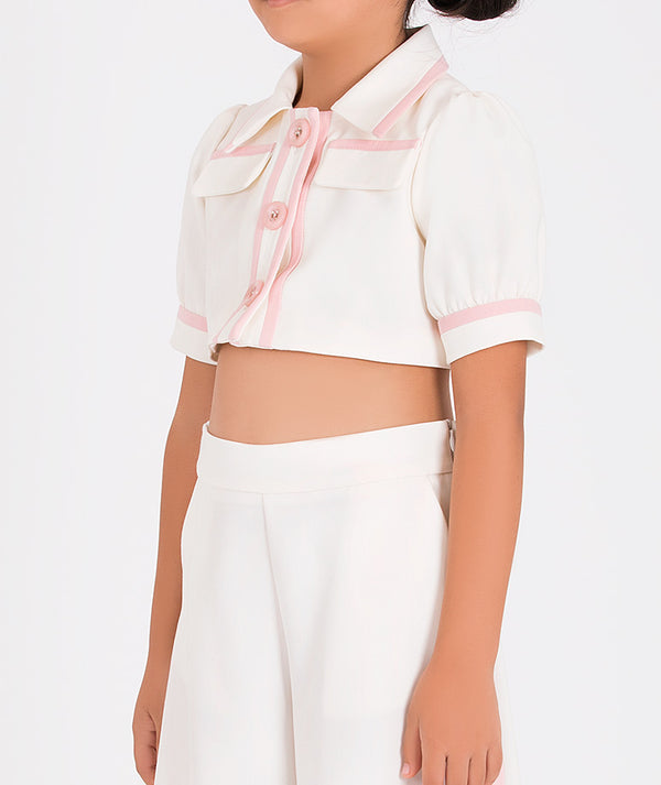 a white and pink two-piece set featuring a cropped jacket and flared pants