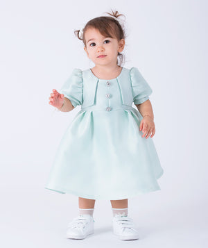 Adorable puff-sleeve baby dress crafted from soft satin with jeweled buttons and pleated detailing. Available in pastel mint and blush pink—perfect for birthdays, holidays, and special family moments. Comfortable, elegant, and picture-ready!