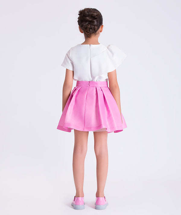 Back view of a two-piece girls outfit with structured top and softly flared skirt, designed for elegant celebrations.