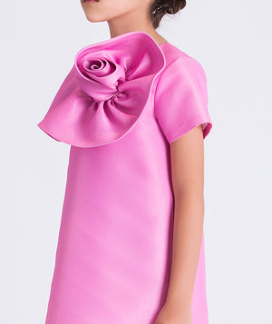 Close-up of sculptural 3D flower detail on a luxury girls dress, highlighting refined craftsmanship and structured fabric