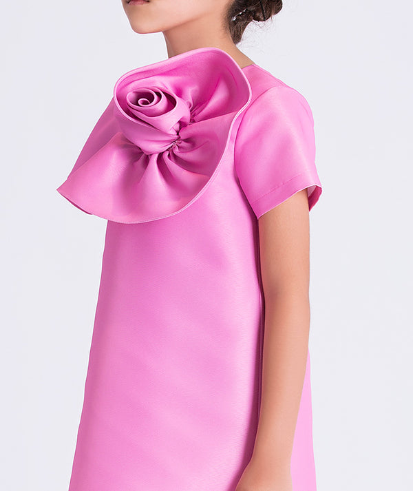 Close-up of sculptural 3D flower detail on a luxury girls dress, highlighting refined craftsmanship and structured fabric