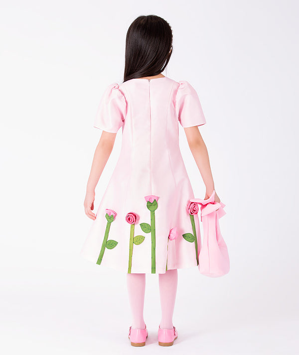 Back view of 3D Rose Appliqué Girls Dress in blush pink structured matte satin for girls ages 3 to 12, highlighting fabric texture and color