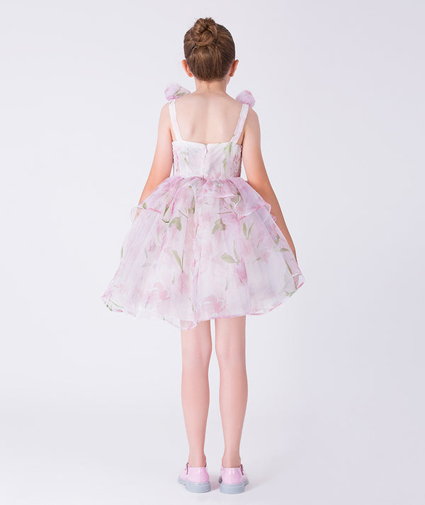 Back view of a floral chiffon girls dress by Mama Luma, showcasing a softly flared silhouette designed for elegant celebrations for ages 3–12.