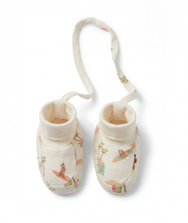 Pair of baby booties with a strap on a white background