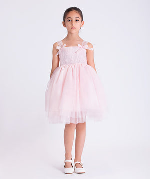6 years old girl wearing a pink dress with bow details on a white background
