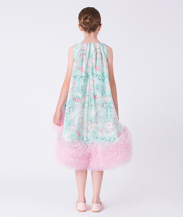 Girl wearing a floral dress with a pink tulle skirt on a white background