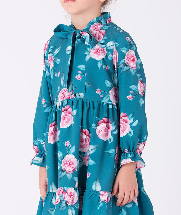 Close-up of a teal floral girls’ dress featuring pink rose prints, long sleeves, and a neck bow detail (3–12Y) — ideal for spring celebrations and birthdays