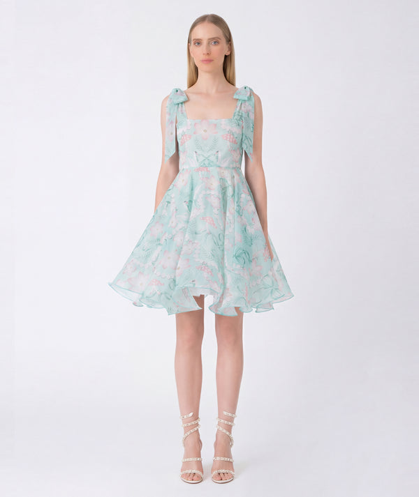 Woman wearing a light blue floral dress on a white background