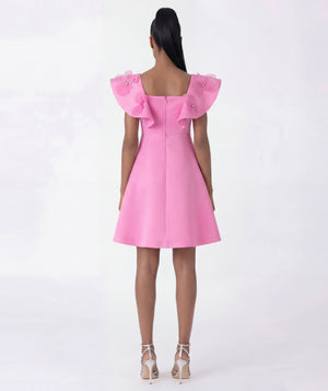 Pink dress with ruffled shoulders on a white background