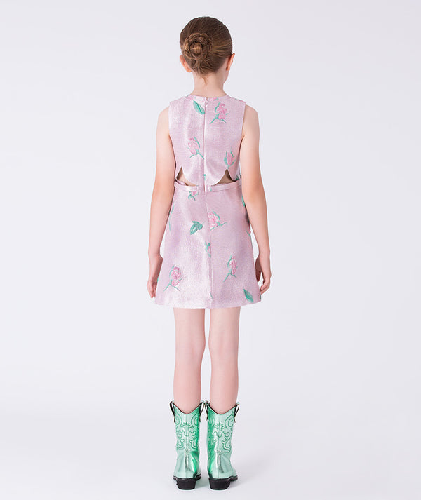 9 years old wearing a light pink dress with floral patterns and green cowboy boots on a white background