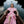 Carica l'immagine nel visualizzatore Galleria, Woman in a pink dress sitting in a boat on a body of water.
